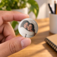 Botton personalizado de 5,8 cm com foto, segurado entre os dedos