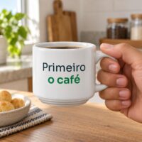 Mão segurando a xícara branca personalizada com a frase Primeiro o café, mostrando o tamanho real